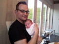 Jules holds his new daughter Camille at home